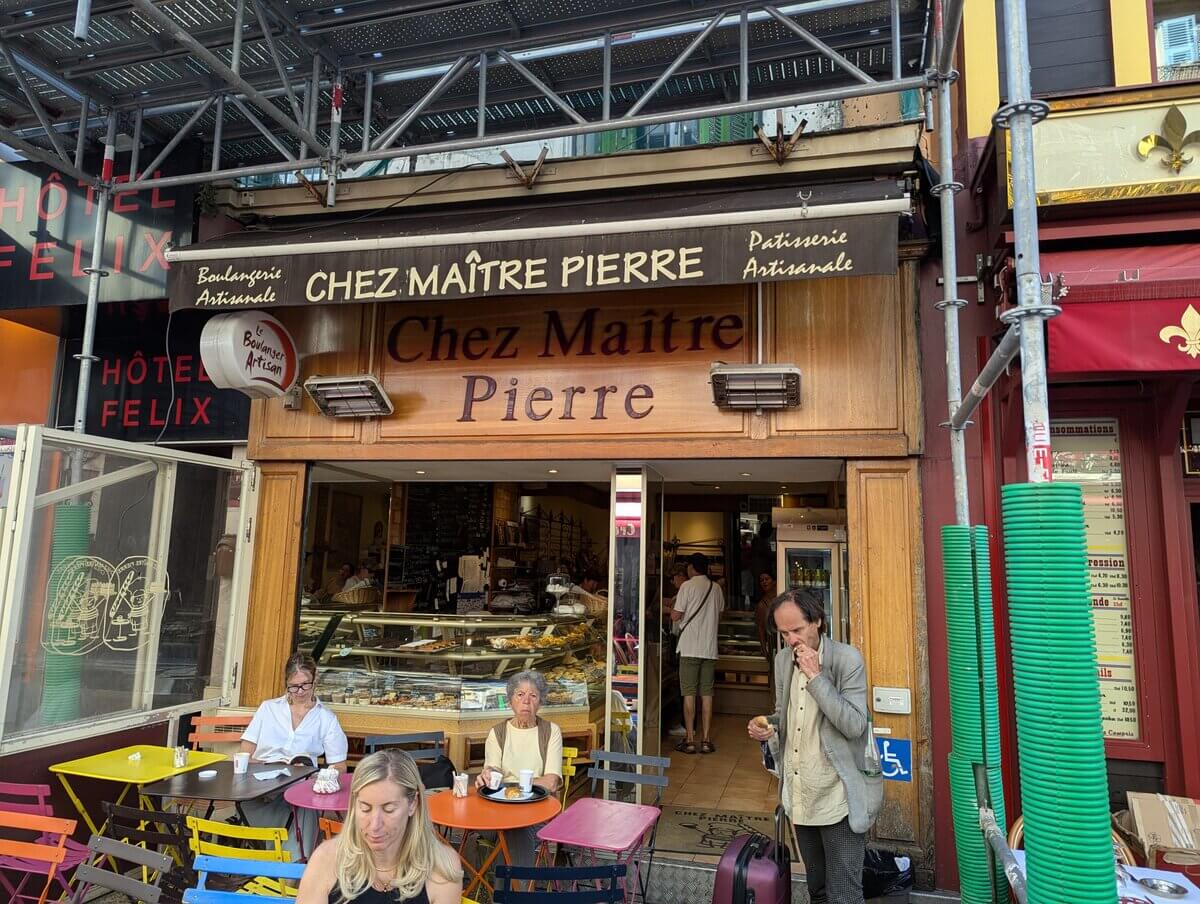 旧市街のパン屋Chez Maître Pierreの外観 カラフルなテラス席と焼き菓子のショーケース