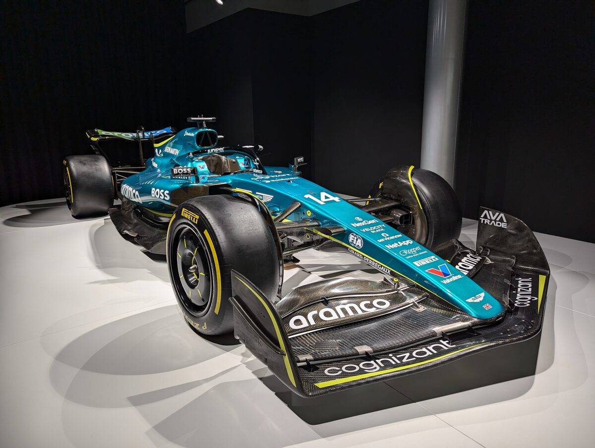 暗い展示室でスポットライトを浴びる2023年のアストンマーティンAMR23 カーナンバー14