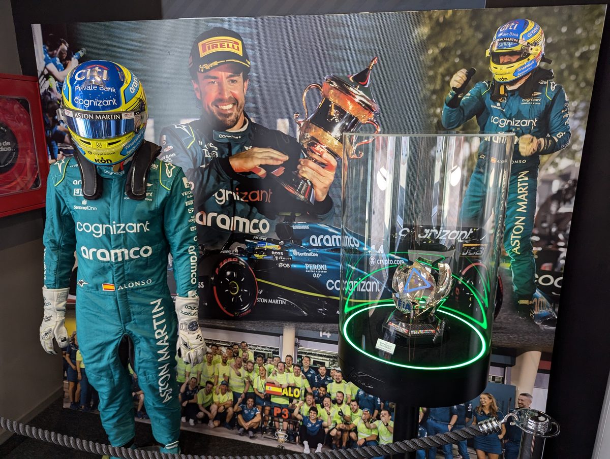アストンマーティン時代のレーシングスーツとトロフィー 2023年バーレーンGP表彰台の写真パネル