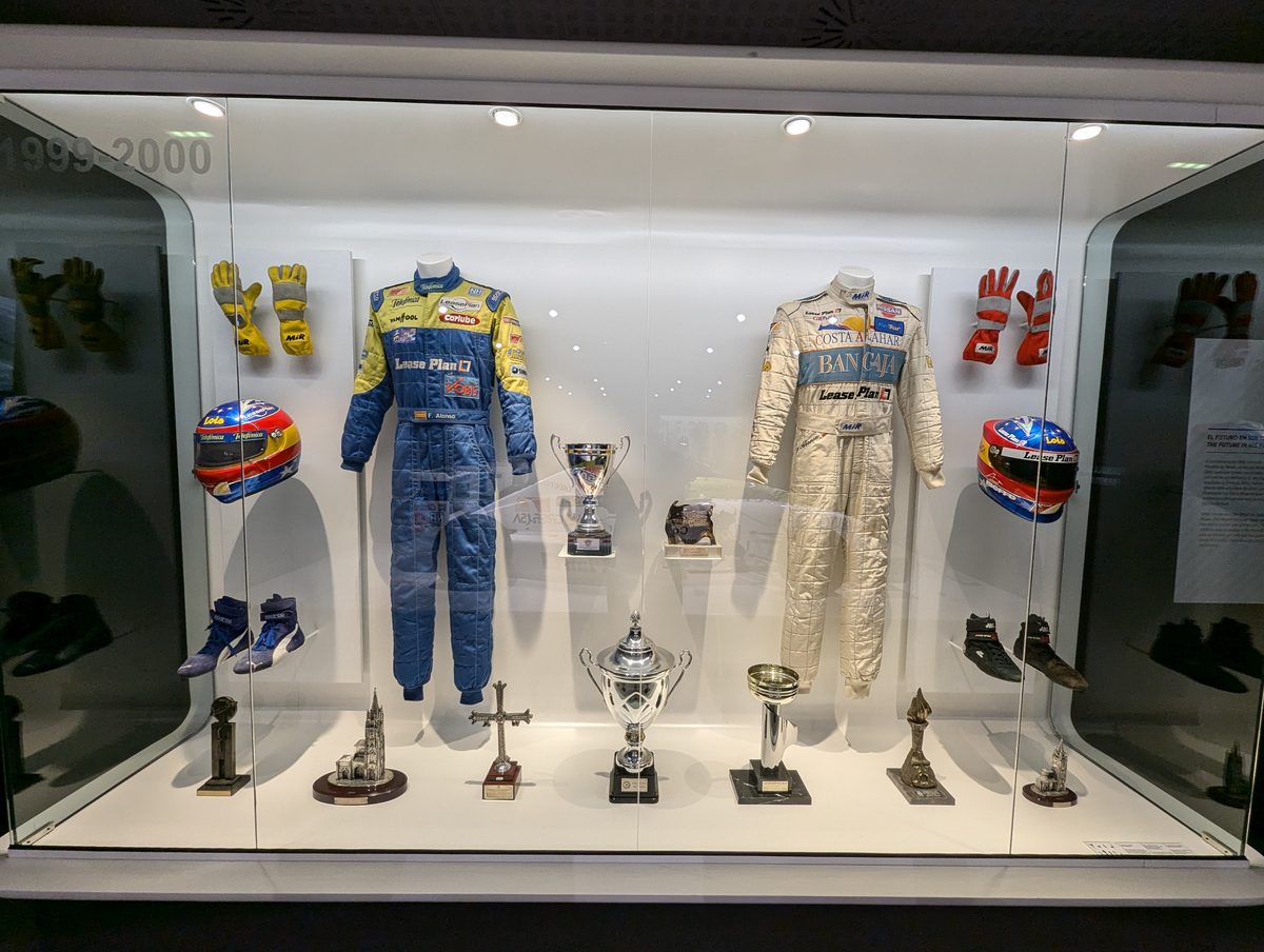 1999-2000年のフォーミュラ・ニッサン時代のレーシングスーツとトロフィーの展示ケース